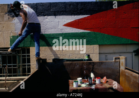 Jericho, Sept 13th 1993; A painter paints a Palestinian flag on the wall of the town's petrol station. Stock Photo