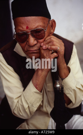 A elderly Nepali man leans on his stick in Durber Square Kathmandu Nepal Stock Photo