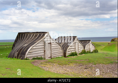 Ancient Upcycled Wooden Upturned Herring Boat shelter made from stern hulls; a weather shed landmark at Lindisfarne on Holy Island, Northumberland Stock Photo