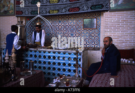 Tearoom Isfahan Iran tea house Esfahan Person smokes water pipe tearoom seamen Ashura Festival muslim prayers on canvas at walls Hassan and Hussein Stock Photo