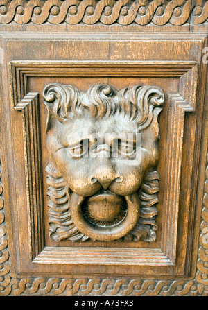 Carved detail resembling a lions head door knocker on a wooden panel on a door in Old Town Square, Prague Stock Photo