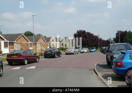 Busy street parking and speed hump on a road in a uk housing estate Stock Photo