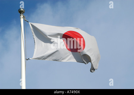 Japanese flag fluttering in the wind against a blue sky Stock Photo