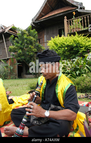 A man blowing the clarinet during the performance of the Malay art of self defence known as Silat in Malaysia Stock Photo