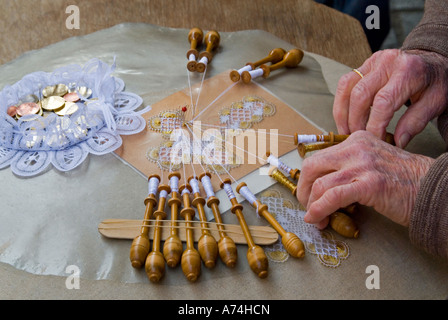 Horizontal close up of an old lady demonstrating the traditional art of bobbin lace-making. Stock Photo