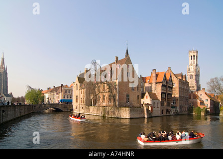 Horizontal cityscape across the canal from Rozenhoedkaai with the Belfry of Bruges or Belfort van Brugge reflected in the water in Bruges. Stock Photo