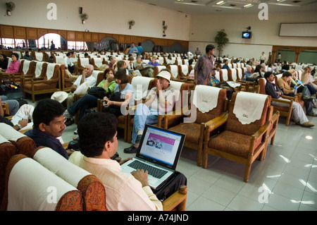 A man on his laptop computer while in the departure lounge of an Indian airport Stock Photo