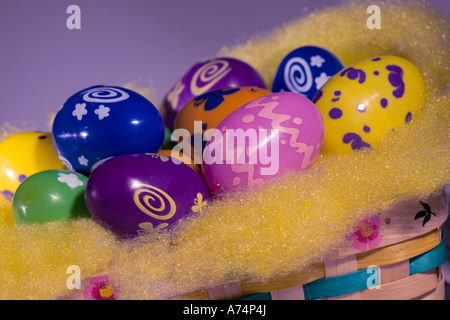 Colourful plastic Easter eggs in a basket, close-up. Stock Photo