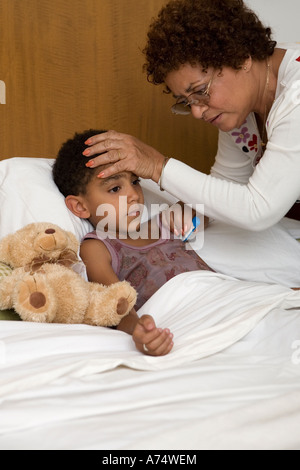 Middle-aged woman taking grandson's temperature
