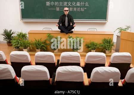 Teacher meditating on desk Stock Photo