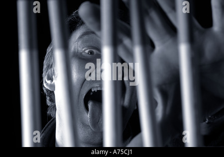 Duotone of smoker trapped behind cigarette bars of addiction Stock Photo