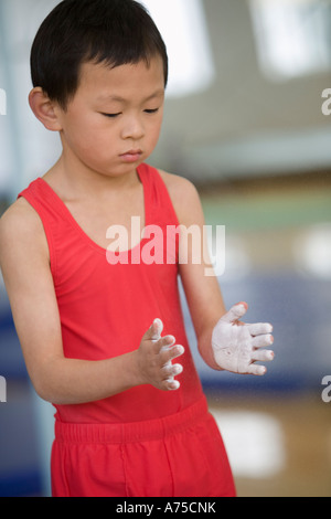 Young boy rubbing chalk on his hands Stock Photo