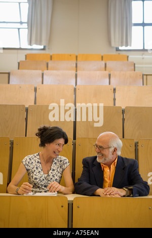 Teachers talking in empty classroom Stock Photo