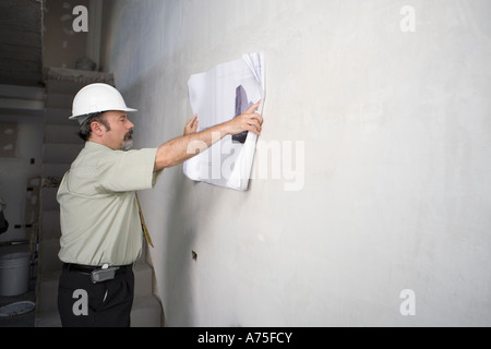 Businessman examining blueprints Stock Photo