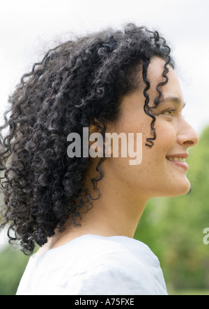 Young woman smiling, side view, portrait Stock Photo