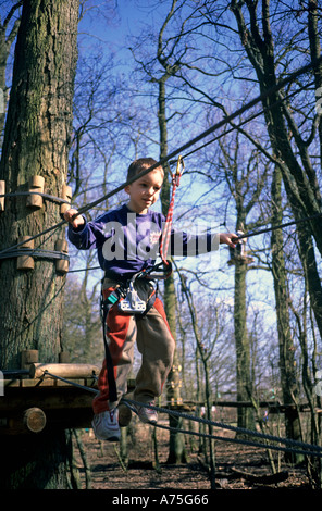 Adventure rope swing boy swinging on heigh Stock Photo