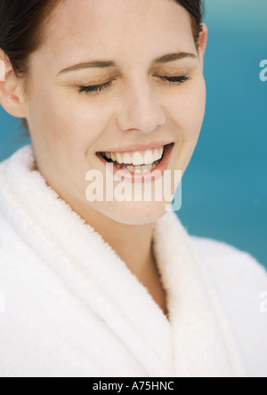 Woman wearing bathrobe, smiling with eyes closed Stock Photo