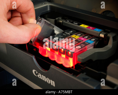 Exchanging replacing an empty used ink cartridge tank in a Canon brand inkjet printer ip4300 Stock Photo