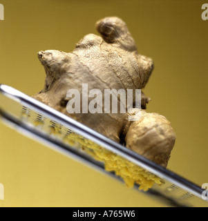 Ginger root on metal grater Stock Photo