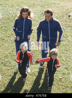 family of four jogging in park Stock Photo