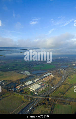 The view from a window of an aircraft over the wing as it is taking off from Heathrow flying over a section of the m25 motorway. Stock Photo