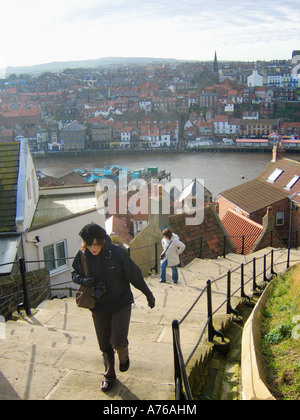 Female walking up the 199 steps that lead to St Mary's Church and Whitby Abbey, on a sunny winter day. North Yorkshire UK Stock Photo