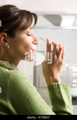 Young woman drinking water, close-up, side view Stock Photo