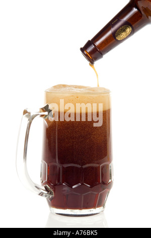 Pint of dark beer being poured into glass on a pure white background. Stock Photo