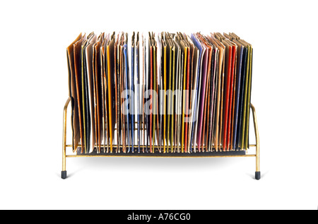 Side on view of old vinyl 45's records stacked in a kitsch seventies holder on a pure white background. Stock Photo