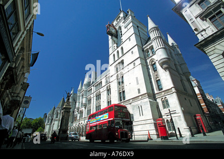 Low wide angle of a traditional red double decker route master bus passing the Royal Courts of Justice aka Law Courts in London. Stock Photo