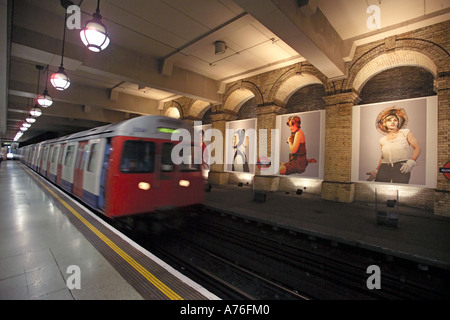 A tube train coming into an empty platform with motion blur at Gloucester Road underground station. Stock Photo