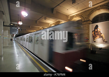 A tube train coming into an empty platform with motion blur at Gloucester Road underground station. Stock Photo