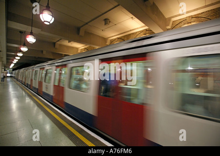 A tube train coming into an empty platform with motion blur at Gloucester Road underground station. Stock Photo