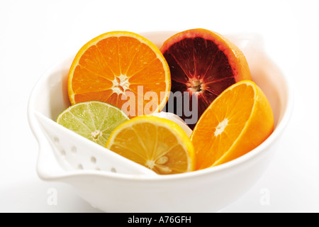 Sliced citrus fruits in bowl Stock Photo