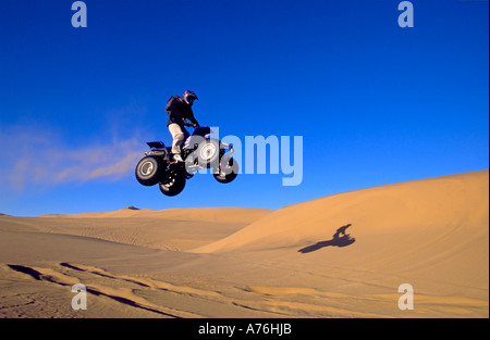 A Quad biker performing freestyle jumps on the sand dunes of the Namibian desert. Stock Photo