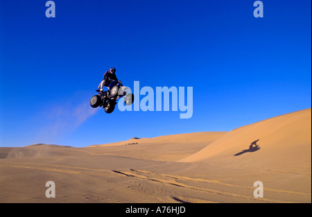 A Quad biker performing freestyle jumps on the sand dunes of the Namibian desert. Stock Photo