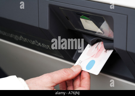 Hand pushing credit card into cash terminal, close-up Stock Photo