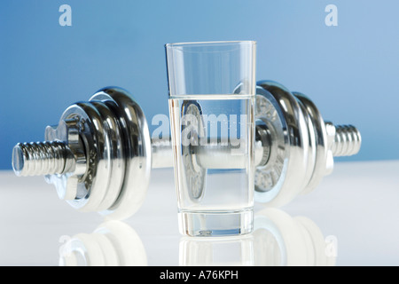 Glass of water, dumbbell in background Stock Photo
