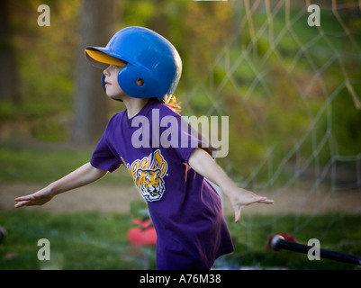 Softball player running to first base after hitting a ball Stock Photo