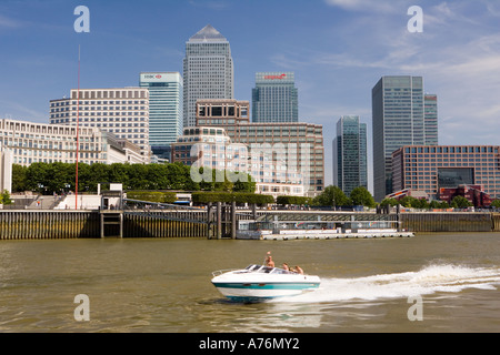 London's impressive skyline from pleasure boat on Thames as speed-boat passes Stock Photo