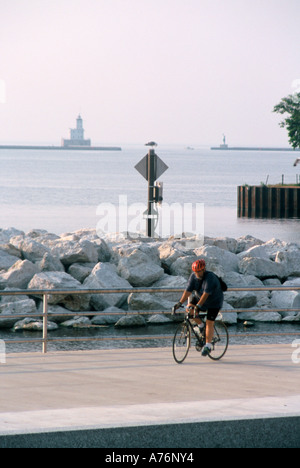 A biker riding along Lake Michigan lakefront bike path in Milwaukee Wisconsin Stock Photo