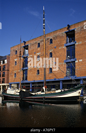 Old traditional sailing boat moored on Atlantic Wharf in front of The Bonded Warehouse Cardiff Bay Cardiff Wales UK Stock Photo