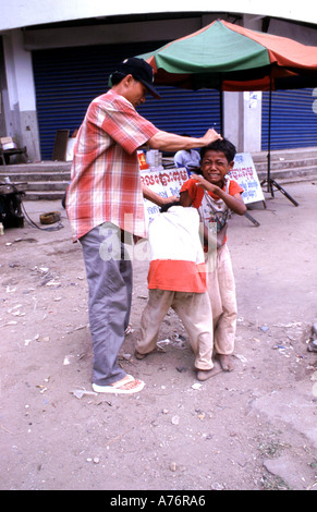 A child is summarily beaten for attempting to steal some fruit. Street Children in Phnom Penh cambodia. Stock Photo