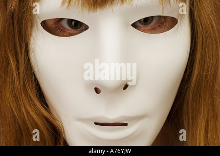 Woman hiding behind mask Stock Photo