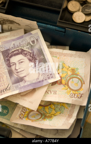 Cash box on market stall stuffed full of £20 and £10 notes Stock Photo