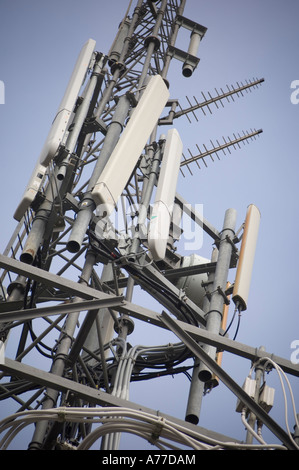 a cluster of mobile cell phone telephone microwave telecommunications aerials and transmitters on a mast in the UK Stock Photo