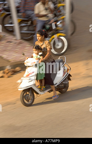 Mother and daughter on a moped with no crash helmet, but common in India. ! Stock Photo