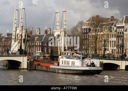 Boat passing open White Skinny Bridge or Magere Brug on Amstel River, Amsterdam Holland Stock Photo