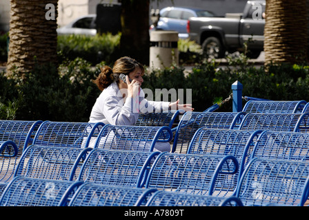 Woman on cell phone in public park Stock Photo