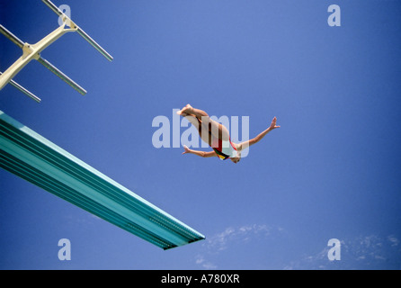 Woman Doing Swan Dive off Diving Board Stock Photo